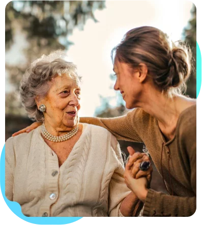 A woman caring for an elderly woman who needs daily assistance